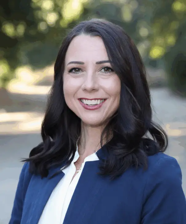 Brooke Grayson smiling outdoors in a navy blazer and white blouse, community leader, REALTOR®, and Rancho Simi Recreation and Park District Board Member.